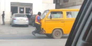 A traffic policeman in Lagos clinging to the commercial bus' bonnet as its driver sped off