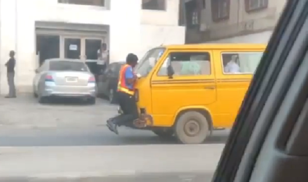 A traffic policeman in Lagos clinging to the commercial bus' bonnet as its driver sped off