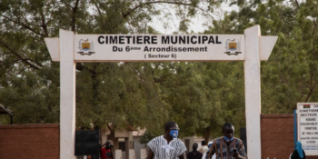 People wearing face masks are seen leaving the funeral of the first victim of the coronavirus, otherwise known as COVID-19 in sub-saharian Africa, in Ouagadougou, on Wednesday, March 18, 2020.