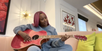 DJ Cuppy playing acoustic guitar