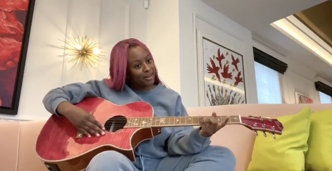 DJ Cuppy playing acoustic guitar