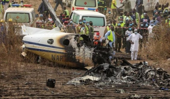 Rescuers and people gather near the debris of a Nigerian air force plane, which according to the aviation minister crashed while approaching the Abuja airport runway, in Abuja, Nigeria February 21, 2021.